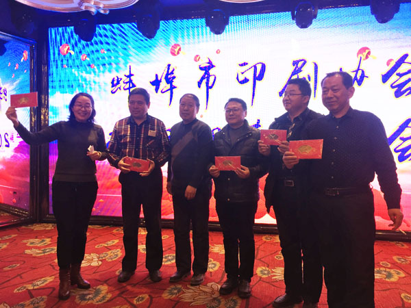 蚌埠市印刷协会副会长、蚌埠市东方彩色印刷厂总经理徐兴国（中）登台抽奖，并与获奖人员合影留念