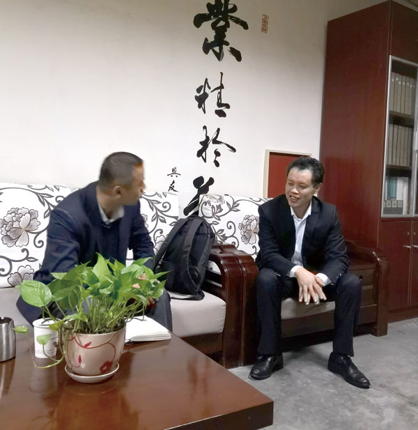 吴勇总经理（右）正在向笔者介绍快马印务公司最新发展情况