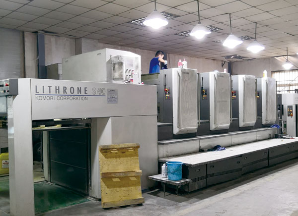 在快马印务公司生产车间里，小全张小森超级丽色龙印刷机正在高速生产中