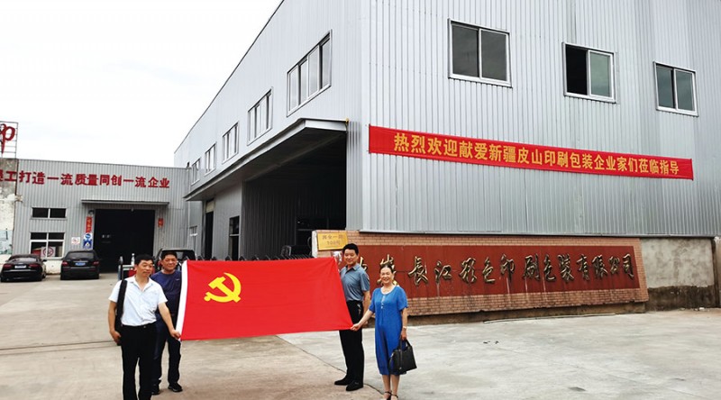 参加此次活动的四位党员手握鲜红的党旗在长江公司大门前合影留念